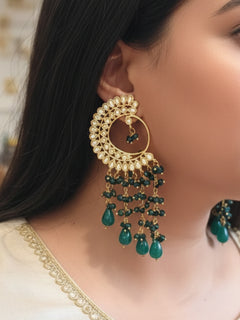 Close-up of a woman wearing an ornate traditional (Gold Polish) Dark Green Long  Earrings with Kundan and Dark Green Beads. Mehendi ceremony look completed with a handcrafted Kundan Earrings. Wedding celebration look enhanced with a statement Kundan Earrings.