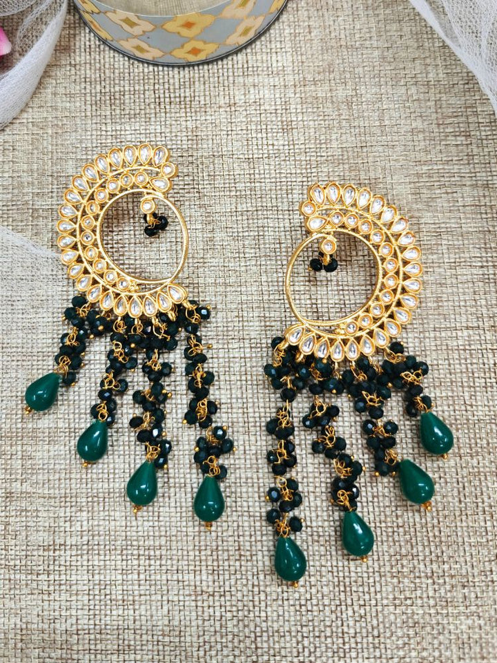 Close-up of an ornate traditional (Gold Polish) Dark Green Long  Earrings with Kundan and Dark Green Beads. Mehendi ceremony look completed with a handcrafted Kundan Earrings. Wedding celebration look enhanced with a statement Kundan Earrings.