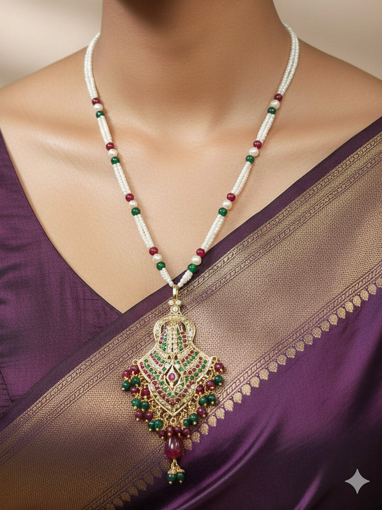 Close-up of a woman wearing an ornate traditional Maroon and Dark Green jadau gold Pendant set and jadau earrings with pearls, Beads and Color Stone. Elegant  look featuring a luxury Jadau artificial Pendant set. Festive celebration look featuring a Jadau artificial Pendant Set.
