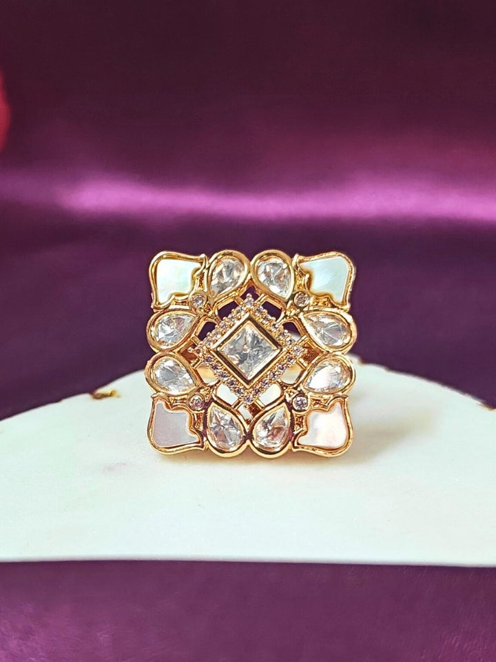 Square ring with kundan and MOP on a purple fabric background