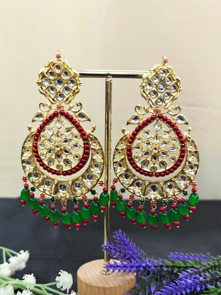 Close-up of an ornate traditional Green Long Kundan Earrings with Kundan, Red/Green Beads and Tumble Beads. A statement artificial Kundan earrings for a wedding guest look in India. A long bridal artificial Kundan earrings for a traditional wedding. Perfect Kundan Earrings for Wedding Functions and Festive.