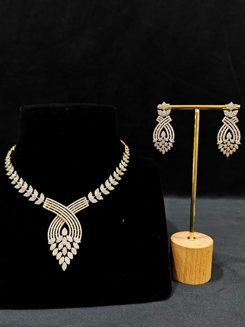 Close-up of an ornate Western American Diamond Gold Collar jewellery set and earrings with American Diamond. Close-up of a featuring an anti-tarnish American diamond artificial necklace. A luxury American diamond necklace set styled beautifully for a wedding guest look in India.