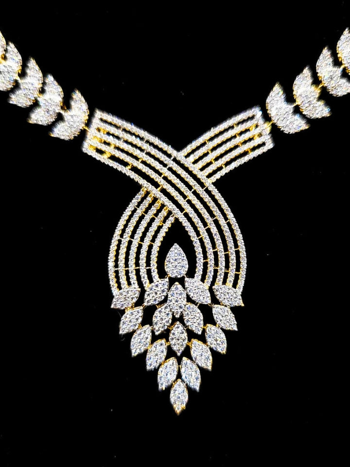 Close-up of an ornate Western American Diamond Gold Collar jewellery set and earrings with American Diamond. Close-up of a featuring an anti-tarnish American diamond artificial necklace. A luxury American diamond necklace set styled beautifully for a wedding guest look in India.