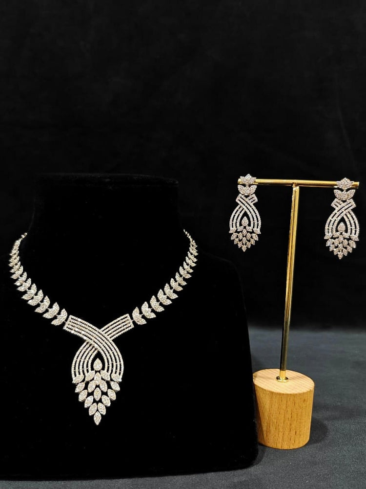 Close-up of an ornate Western American Diamond Silver Collar jewellery set and earrings with American Diamond. Close-up of a featuring an anti-tarnish American diamond artificial necklace. A luxury American diamond necklace set styled beautifully for a wedding guest look in India.