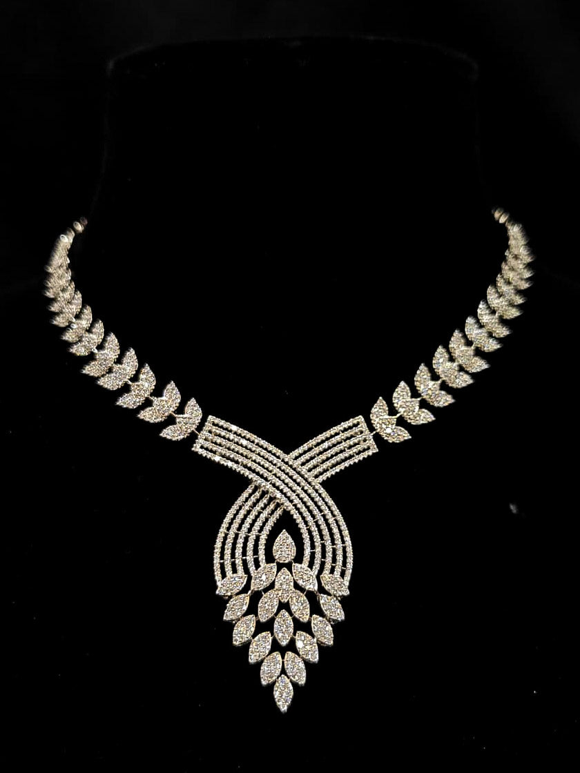 Close-up of an ornate Western American Diamond Silver Collar jewellery set and earrings with American Diamond. Close-up of a featuring an anti-tarnish American diamond artificial necklace. A luxury American diamond necklace set styled beautifully for a wedding guest look in India.