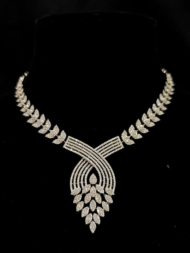 Close-up of an ornate Western American Diamond Silver Collar jewellery set and earrings with American Diamond. Close-up of a featuring an anti-tarnish American diamond artificial necklace. A luxury American diamond necklace set styled beautifully for a wedding guest look in India.