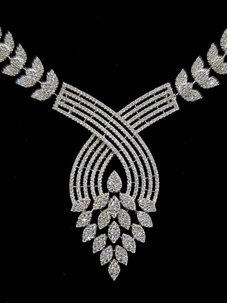 Close-up of an ornate Western American Diamond Silver Collar jewellery set and earrings with American Diamond. Close-up of a featuring an anti-tarnish American diamond artificial necklace. A luxury American diamond necklace set styled beautifully for a wedding guest look in India.