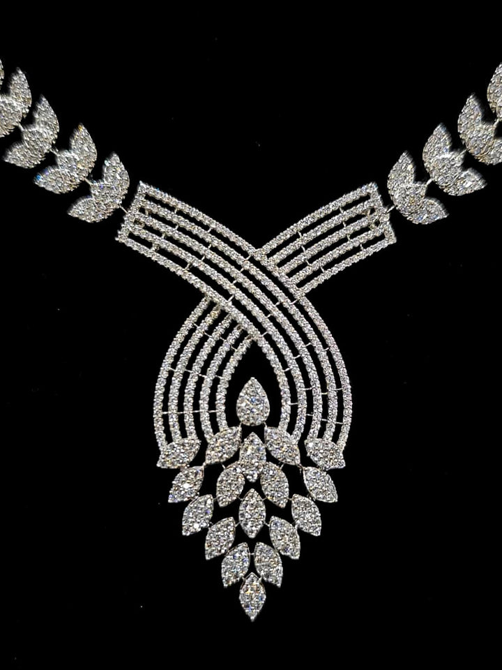 Close-up of an ornate Western American Diamond Silver Collar jewellery set and earrings with American Diamond. Close-up of a featuring an anti-tarnish American diamond artificial necklace. A luxury American diamond necklace set styled beautifully for a wedding guest look in India.