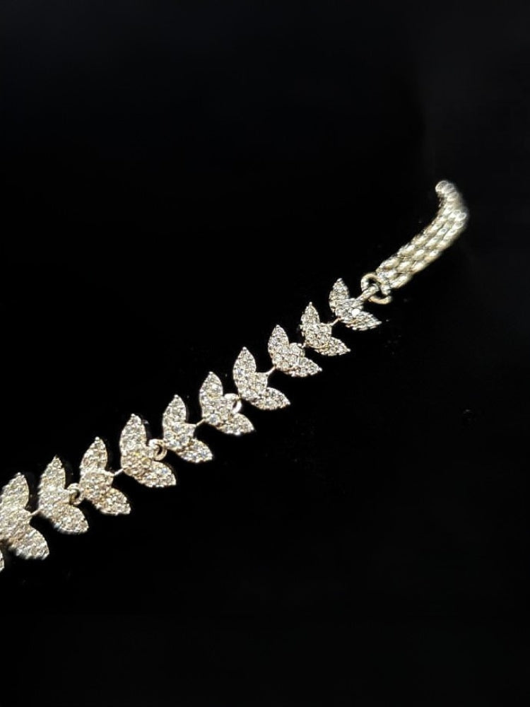 Close-up of an ornate Western American Diamond Silver Collar jewellery set and earrings with American Diamond. Close-up of a featuring an anti-tarnish American diamond artificial necklace. A luxury American diamond necklace set styled beautifully for a wedding guest look in India.