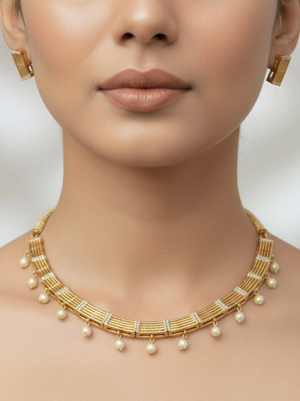 Close-up of a woman wearing an ornate traditional (Gold Polish) Collar jewellery set and earrings with American Diamond and Pearl. Festive saree styling completed with an elegant artificial Pearl jewelry piece. Festive party wear look featuring a Collar Pearl artificial jewelry piece.