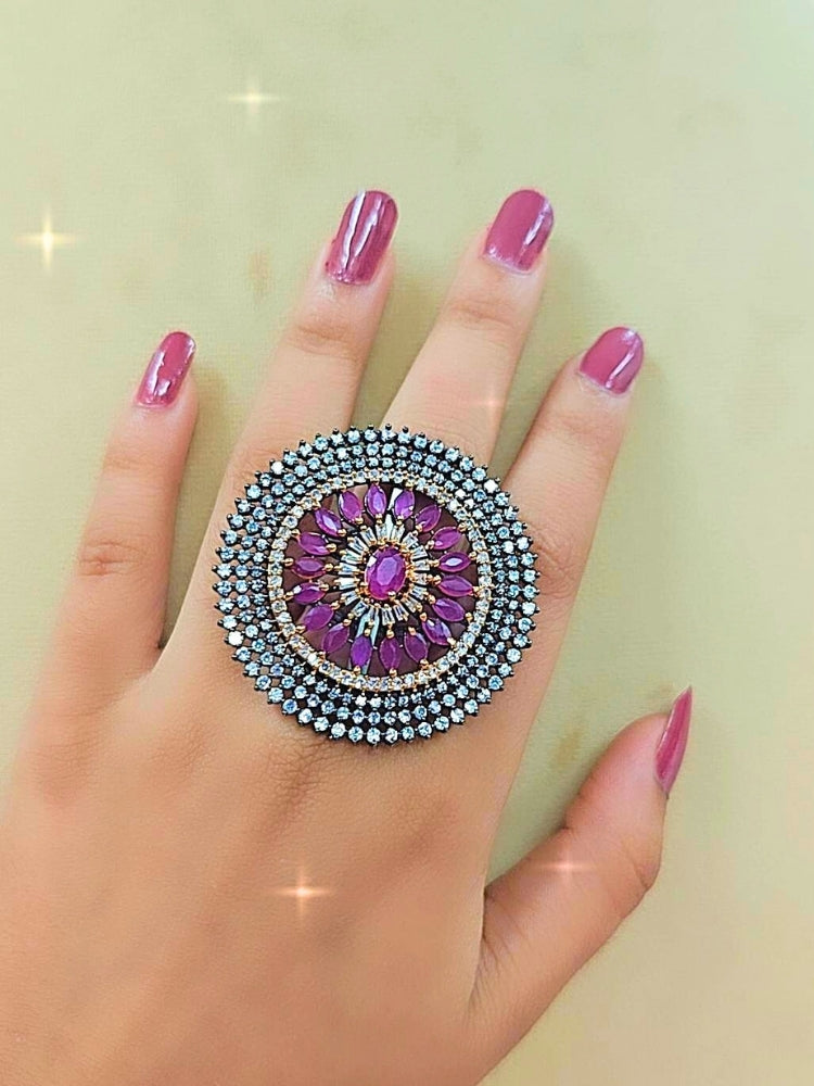 Close-up of a woman wearing an ornate Indo-Western Pink Diamond Ring with American Diamond and Colored Stones. Wedding guest wearing a statement artificial American Diamond cocktail ring. Woman wearing a bridal artificial American Diamond ring for wedding celebrations.