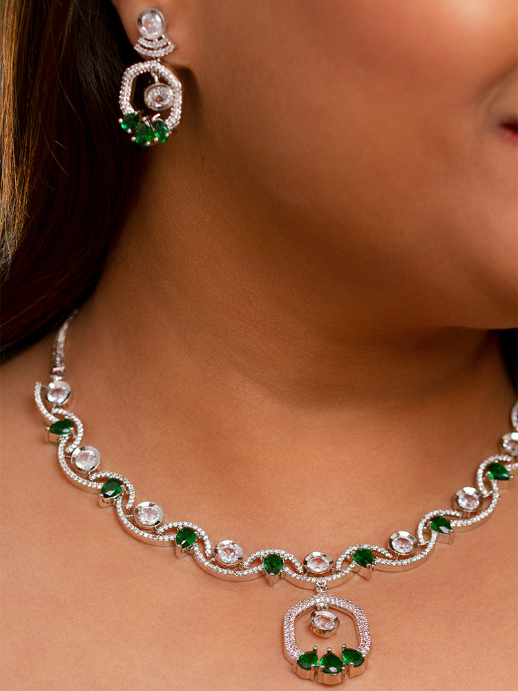 Elegant woman wearing a luxurious artificial diamond necklace with green colored gemstones and matching earrings, perfect for high-profile wedding receptions and formal galas. This high-end artificial diamond jewelry set combines style, elegance, and affordability for special occasions.