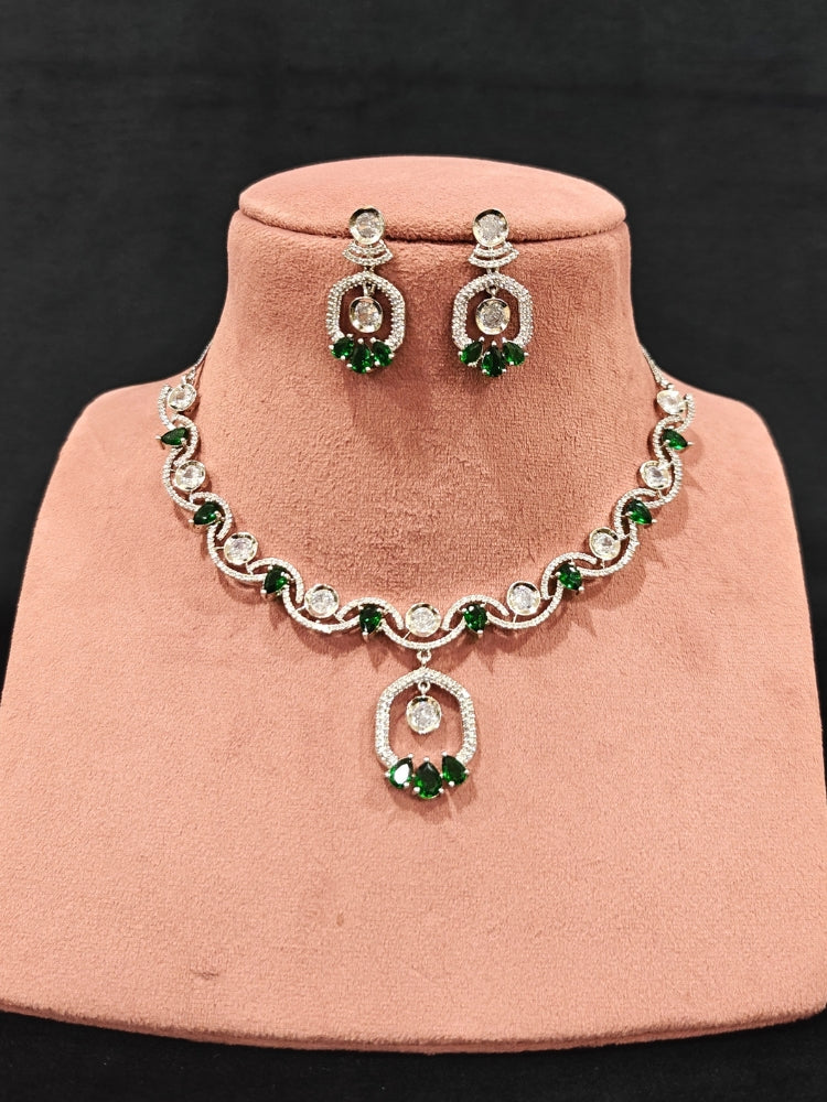 Close-up of an ornate Indo-western Green (Silver Polish) Collar jewellery set and earrings with American Diamond and Colored Stones. Elegant festive look with a high-quality imitation American diamond necklace set. Party wear outfit completed with a lightweight American diamond necklace.