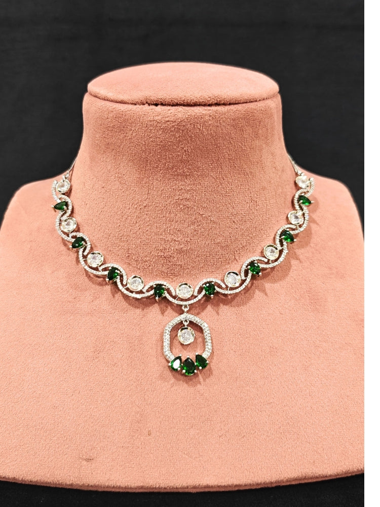 Close-up of an ornate Indo-western Green (Silver Polish) Collar jewellery set and earrings with American Diamond and Colored Stones. Elegant festive look with a high-quality imitation American diamond necklace set. Party wear outfit completed with a lightweight American diamond necklace.