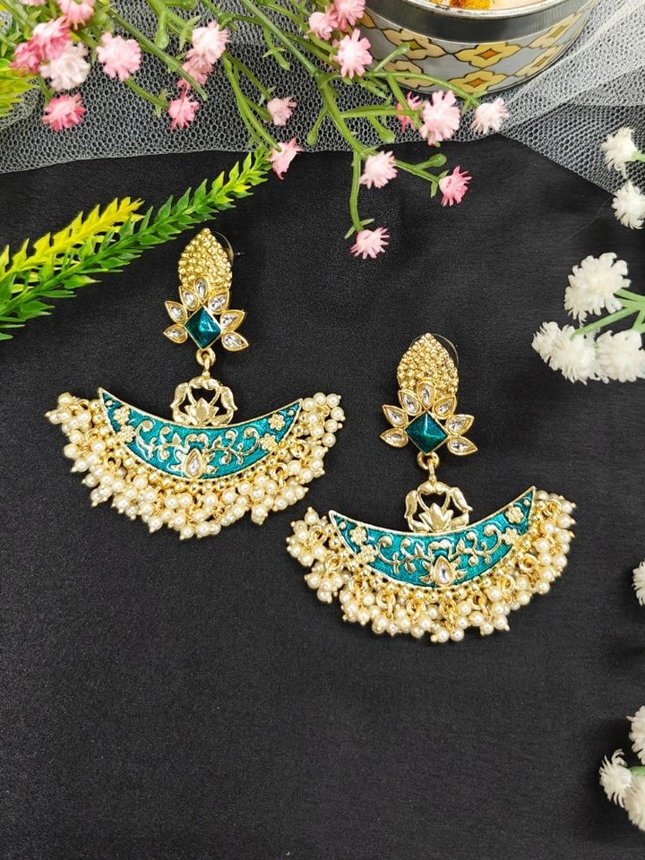 Close-up of an ornate traditional Blue Meenakari gold Earrings with Pearls, Kundan and Meenakari. Mehendi ceremony look completed with a handcrafted Meenakari Earrings. Wedding guest wearing a lightweight Meenakari artificial Earrings.
