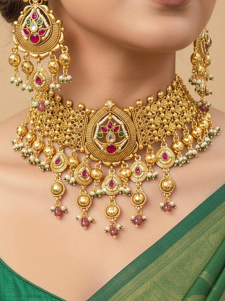 Close-up of an ornate traditional (Bright Gold Polish) Choker jewellery set and earrings with Pearl and Colored Stone. Woman wearing a vibrant Colored Stone artificial jewelry set for celebrations. Wedding function styling with a premium Colored Stone imitation necklace.