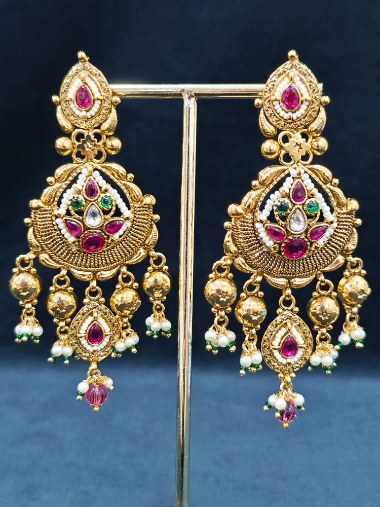 Close-up of an ornate traditional (Bright Gold Polish) Choker jewellery set and earrings with Pearl and Colored Stone. Woman wearing a vibrant Colored Stone artificial jewelry set for celebrations. Wedding function styling with a premium Colored Stone imitation necklace.