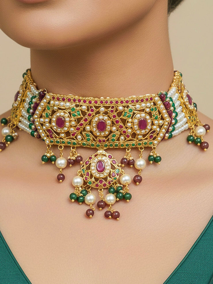 Close-up of a woman wearing an ornate traditional Choker jadau gold jewellery set and  jadau earrings with crystals beads and gemstones. Perfect Jadau necklace set for weddings and festivals. Bride showcasing a royal Jadau necklace set in India.