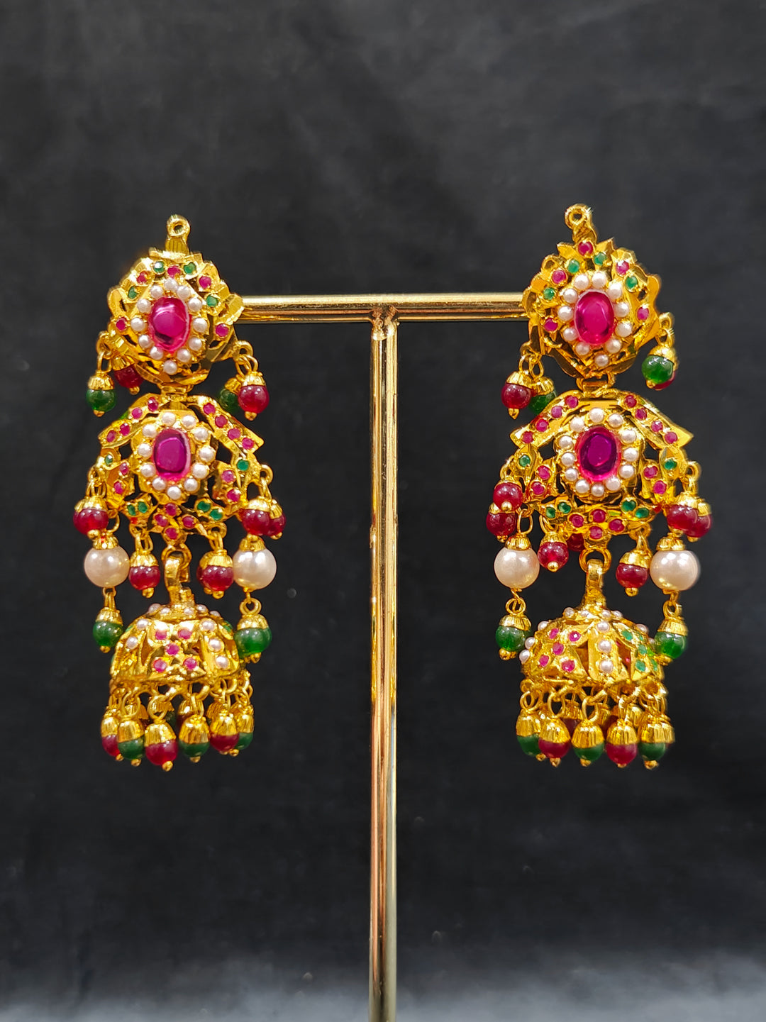 Close-up of a woman wearing an ornate traditional Choker jadau gold jewellery set and  jadau earrings with crystals beads and gemstones. Perfect Jadau necklace set for weddings and festivals. Elegant reception look featuring a luxury Jadau artificial jewelry set.