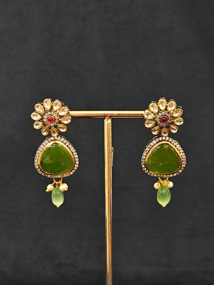 Close-up of an ornate traditional (Black Polish) Mehendi Green long jewellery set and earrings with Mehendi Green Colored Stones, Tumble Beads, Pearls and American Diamond. Woman wearing trending Colored Stone artificial jewelry for wedding season in India. Festive celebration look enhanced with traditional Colored Stone jewelry.