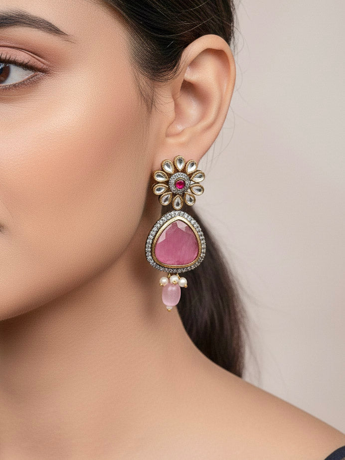 Close-up of a woman wearing an ornate traditional Pink long jewellery set and earrings with Pink Colored Stones, Tumble Beads, Pearls and American Diamond. Woman wearing trending Colored Stone artificial jewelry for wedding season in India. Festive celebration look enhanced with traditional Colored Stone jewelry.