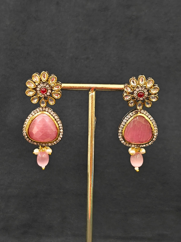 Close-up of an ornate traditional Pink long jewellery set and earrings with Pink Colored Stones, Tumble Beads, Pearls and American Diamond. Woman wearing trending Colored Stone artificial jewelry for wedding season in India. Festive celebration look enhanced with traditional Colored Stone jewelry.