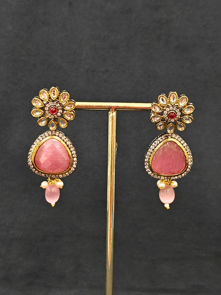 Close-up of an ornate traditional Pink long jewellery set and earrings with Pink Colored Stones, Tumble Beads, Pearls and American Diamond. Woman wearing trending Colored Stone artificial jewelry for wedding season in India. Festive celebration look enhanced with traditional Colored Stone jewelry.