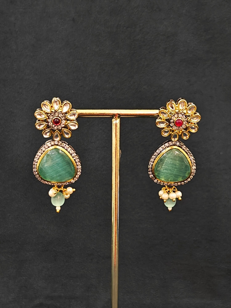 Close-up of an ornate traditional (Black Polish) Sea Green long jewellery set and earrings with Sea Green Colored Stones, Tumble Beads, Pearls and American Diamond. Woman wearing trending Colored Stone artificial jewelry for wedding season in India. Festive celebration look enhanced with traditional Colored Stone jewelry.
