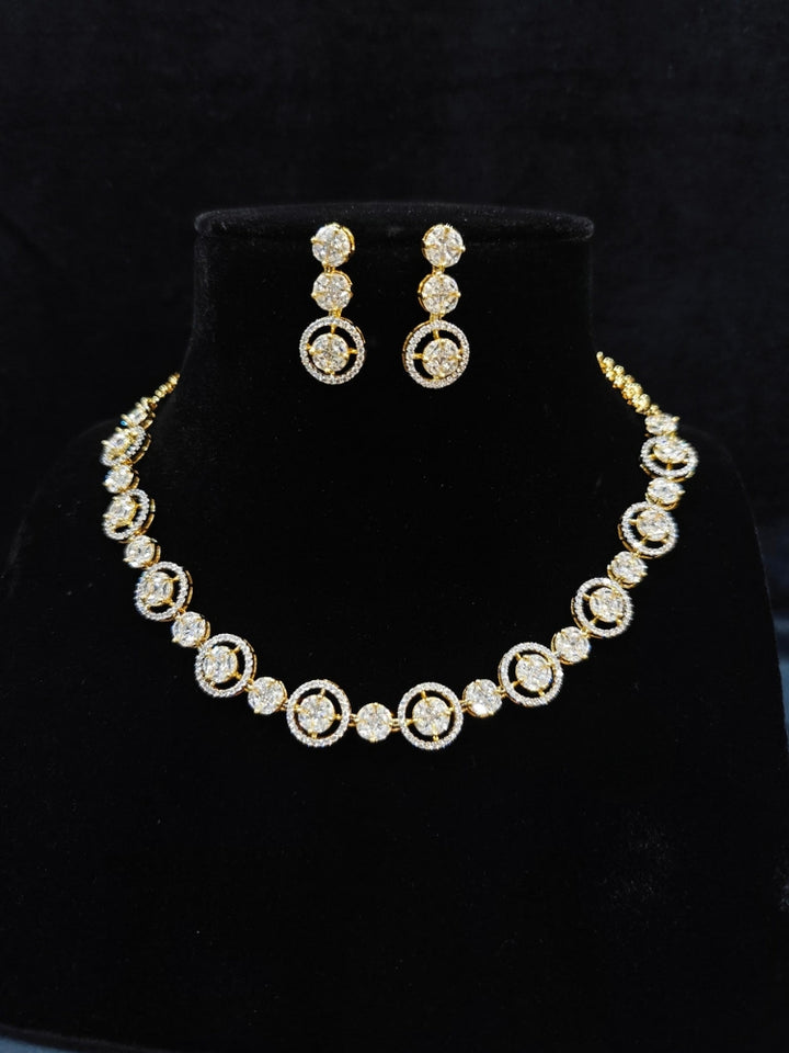 Close-up of an ornate Indo-western Diamond gold Collar jewellery set and earrings with American Diamond. Close-up of a cocktail party look featuring a premium American diamond necklace. Perfect American Diamond necklace set for Parties and festivals.