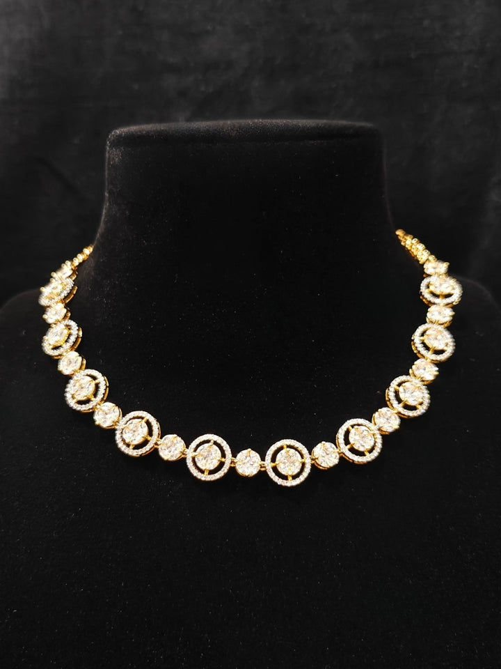 Close-up of an ornate Indo-western Diamond gold Collar jewellery set and earrings with American Diamond. Close-up of a cocktail party look featuring a premium American diamond necklace. Perfect American Diamond necklace set for Parties and festivals.