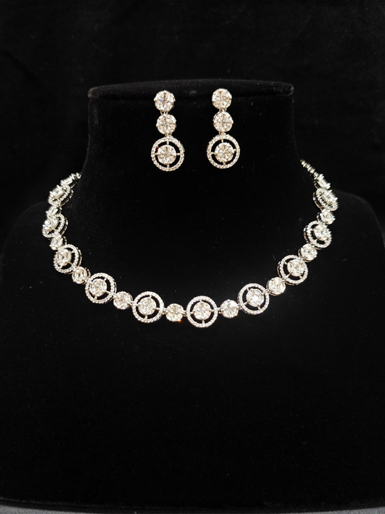 Close-up of an ornate Indo-western Diamond Silver Collar jewellery set and earrings with American Diamond. Close-up of a cocktail party look featuring a premium American diamond necklace. Perfect American Diamond necklace set for Parties and festivals.