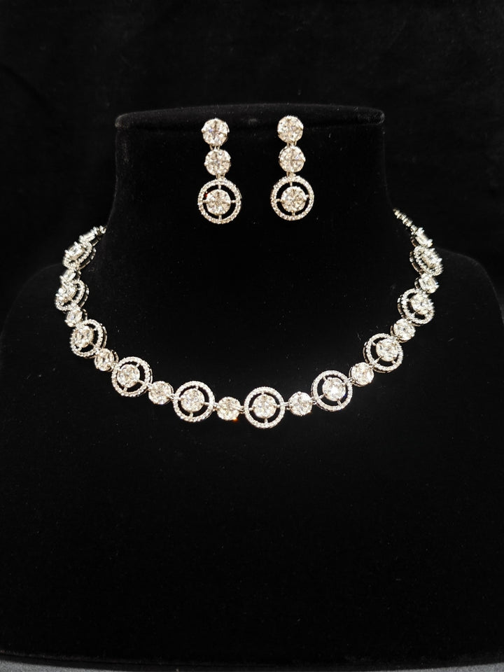 Close-up of an ornate Indo-western Diamond Silver Collar jewellery set and earrings with American Diamond. Close-up of a cocktail party look featuring a premium American diamond necklace. Perfect American Diamond necklace set for Parties and festivals.