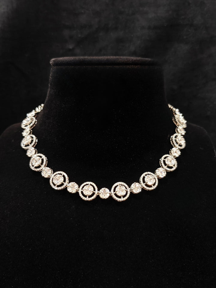 Close-up of an ornate Indo-western Diamond Silver Collar jewellery set and earrings with American Diamond. Close-up of a cocktail party look featuring a premium American diamond necklace. Perfect American Diamond necklace set for Parties and festivals.