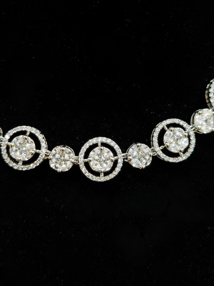Close-up of an ornate Indo-western Diamond Silver Collar jewellery set and earrings with American Diamond. Close-up of a cocktail party look featuring a premium American diamond necklace. Perfect American Diamond necklace set for Parties and festivals.