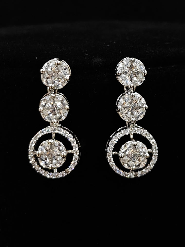Close-up of an ornate Indo-western Diamond Silver Collar jewellery set and earrings with American Diamond. Close-up of a cocktail party look featuring a premium American diamond necklace. Perfect American Diamond necklace set for Parties and festivals.
