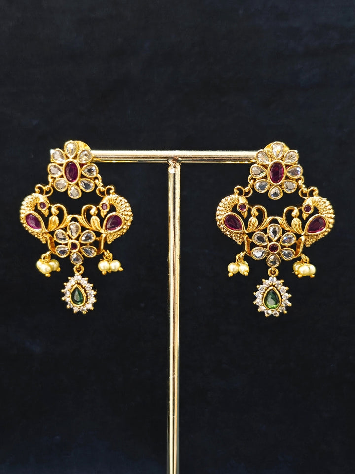 Close-up of American Diamond stonework with red and green accents on gold