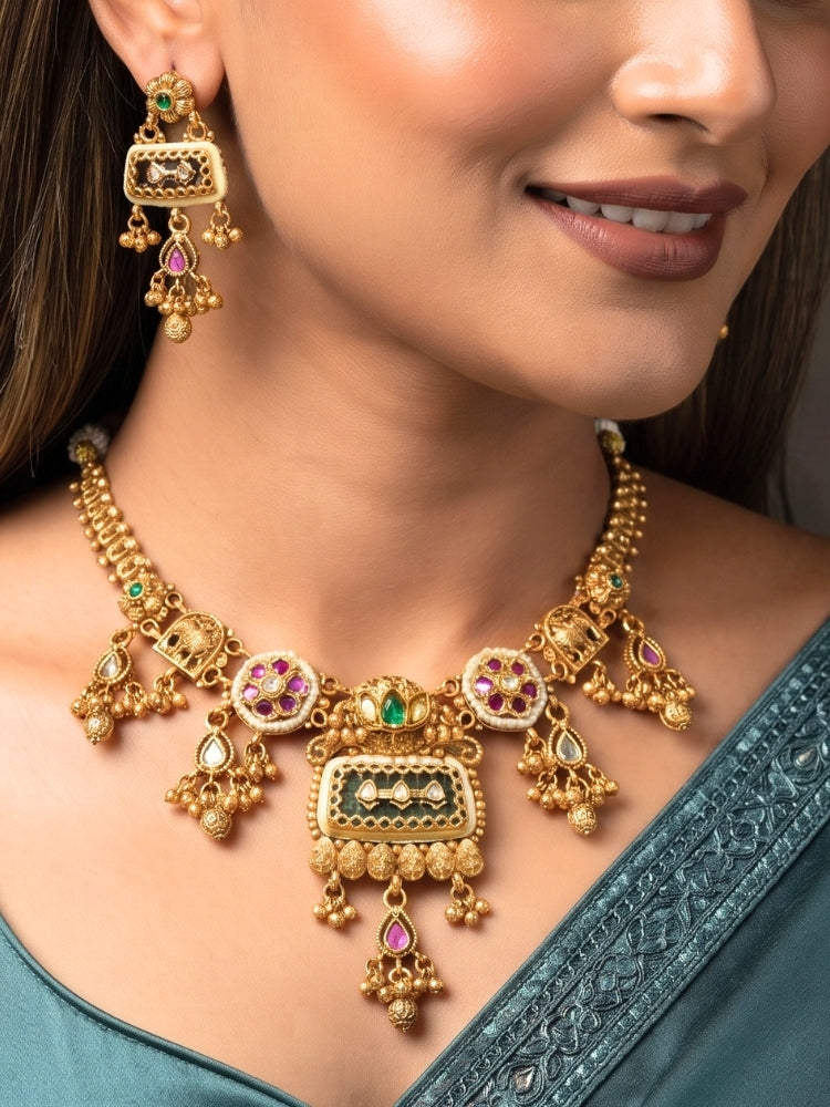 Woman wearing a short gold Heritage necklace set with a teal silk saree