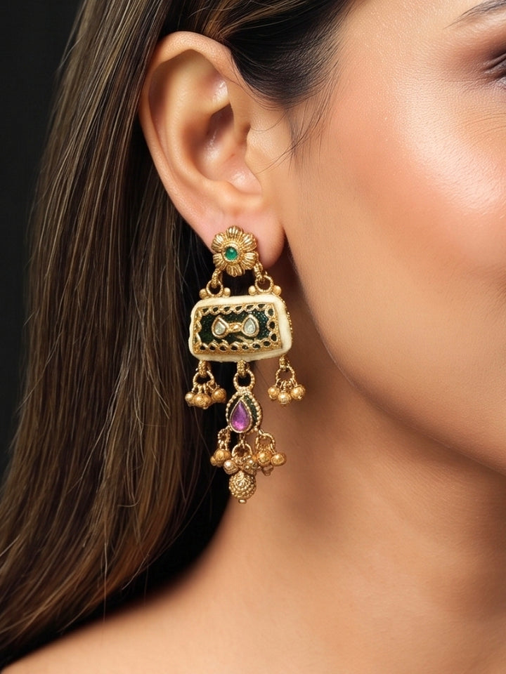 Close-up of gold earrings with Kundan panel, pink drop and ghungroo bells