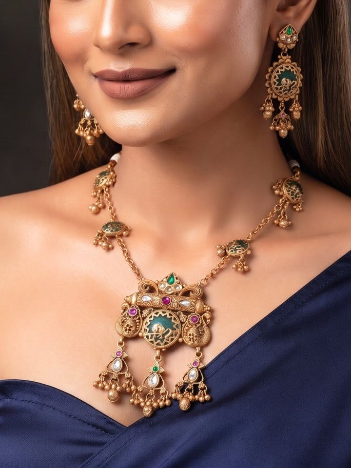 Woman wearing medium-length antique gold Heritage necklace with navy blue saree